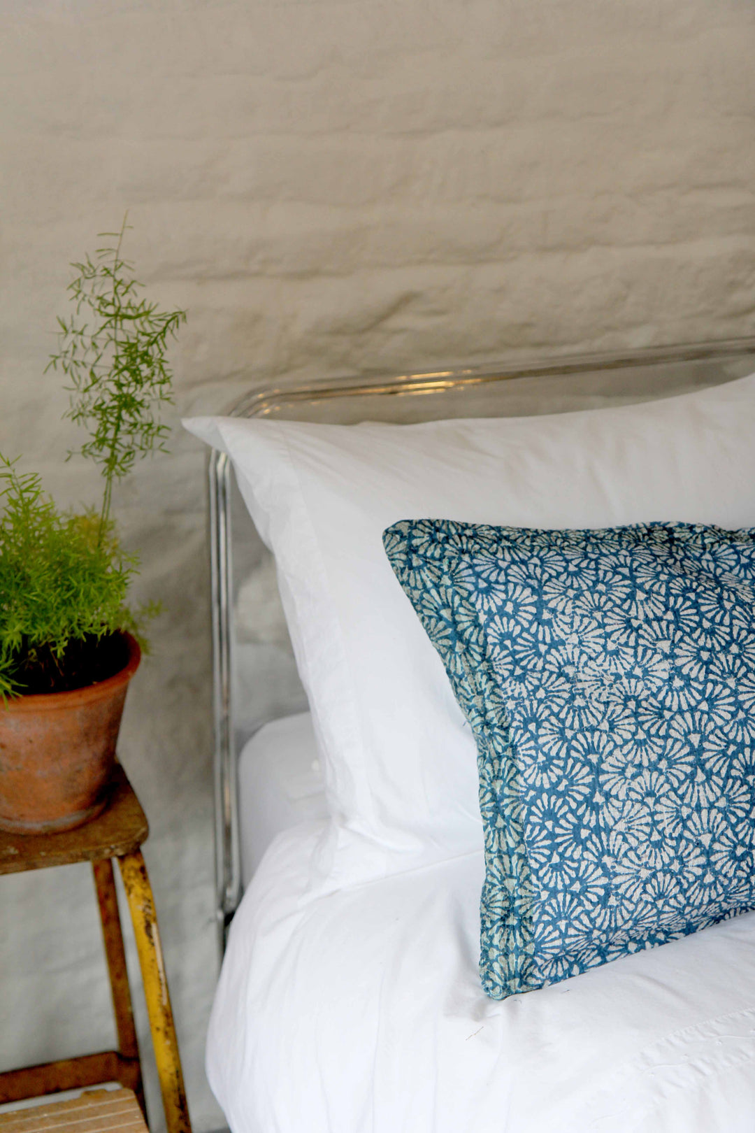 oblong vintage sari kantha cushion with blue block print design on bed