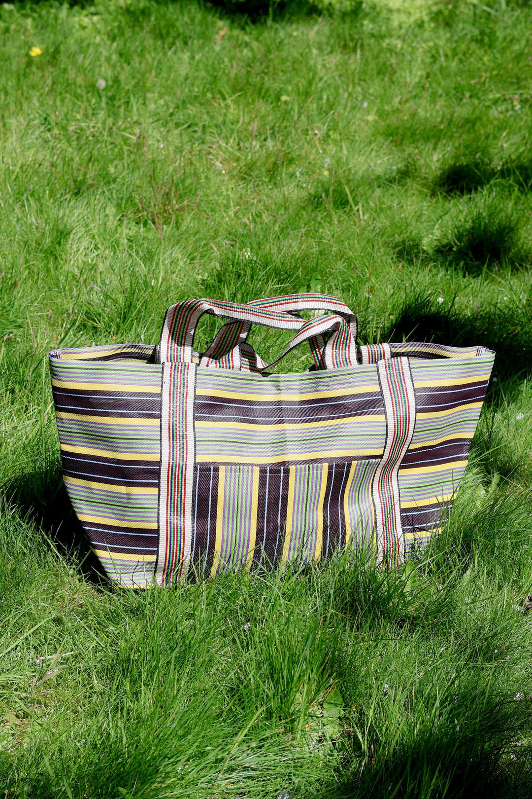 Striped tote bag on a grassy surface