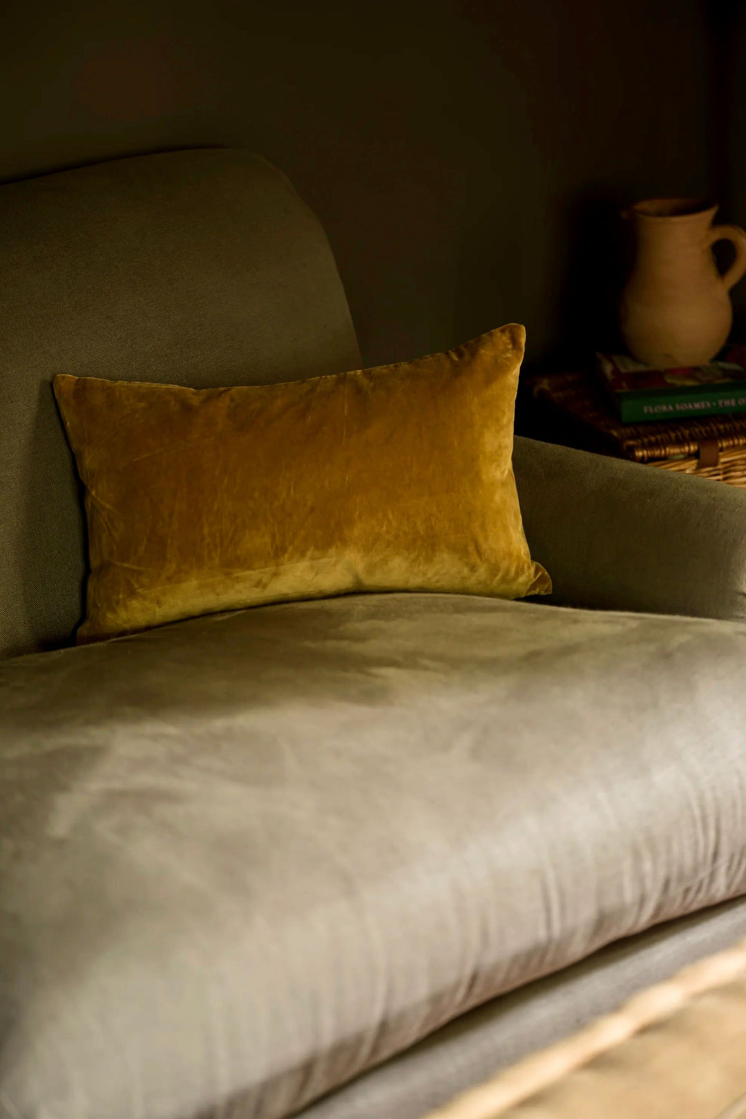 Yellow pillow on a gray sofa with a dimly lit background