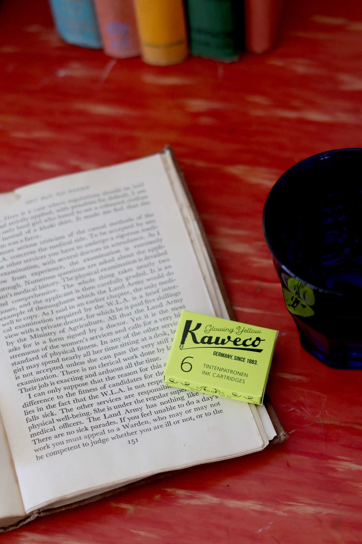 Open book with a yellow Kaweco pencil case on a red surface