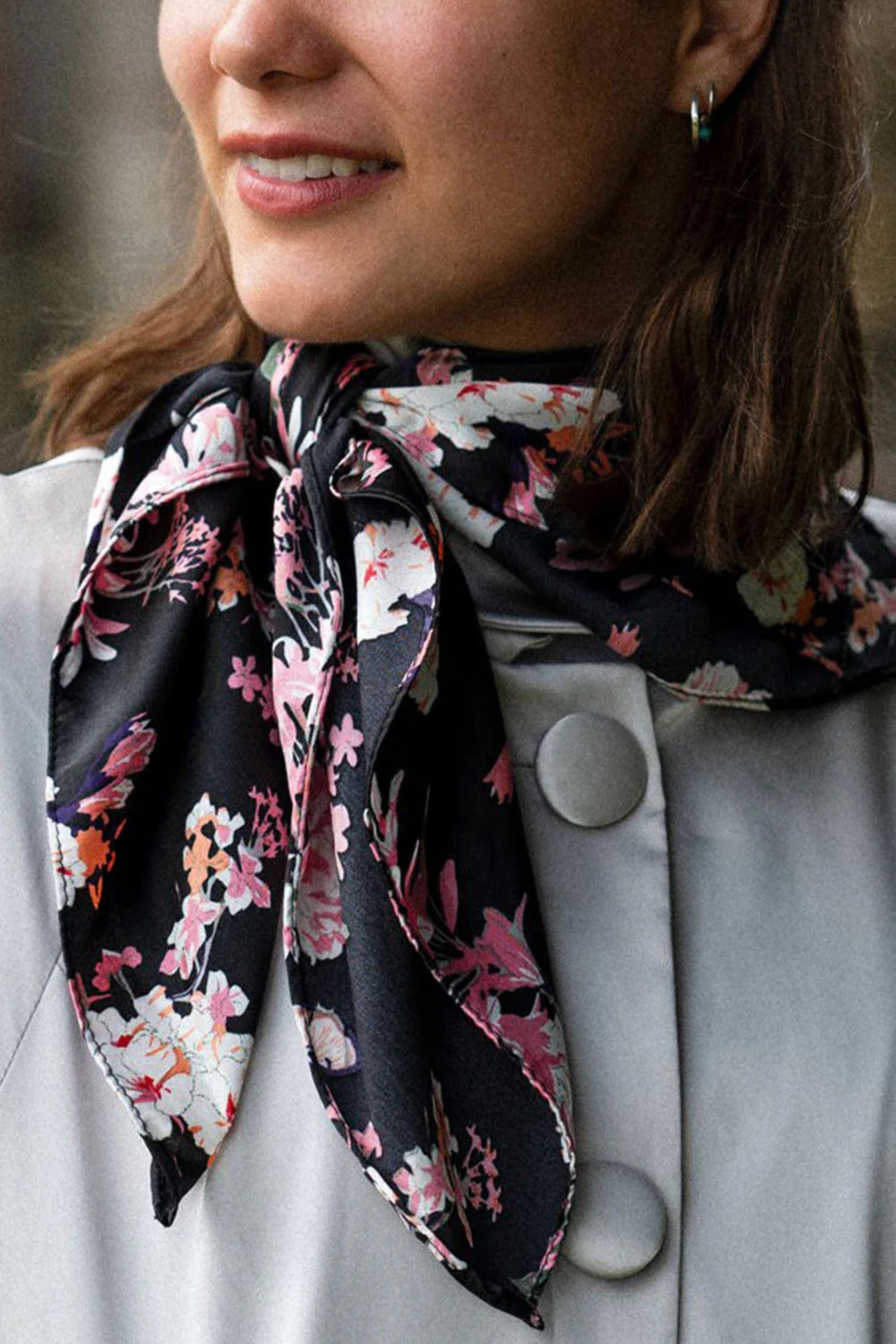 Woman wearing a floral scarf around her neck with a blurred background