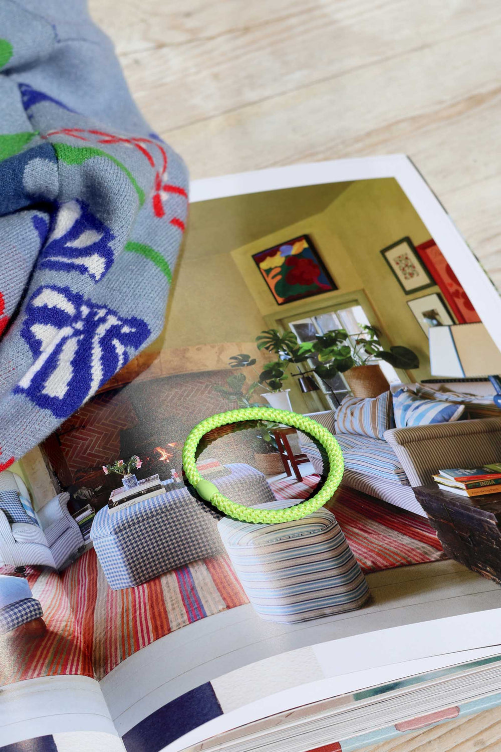 Colorful sweater with a pattern next to an open magazine showing a living room.