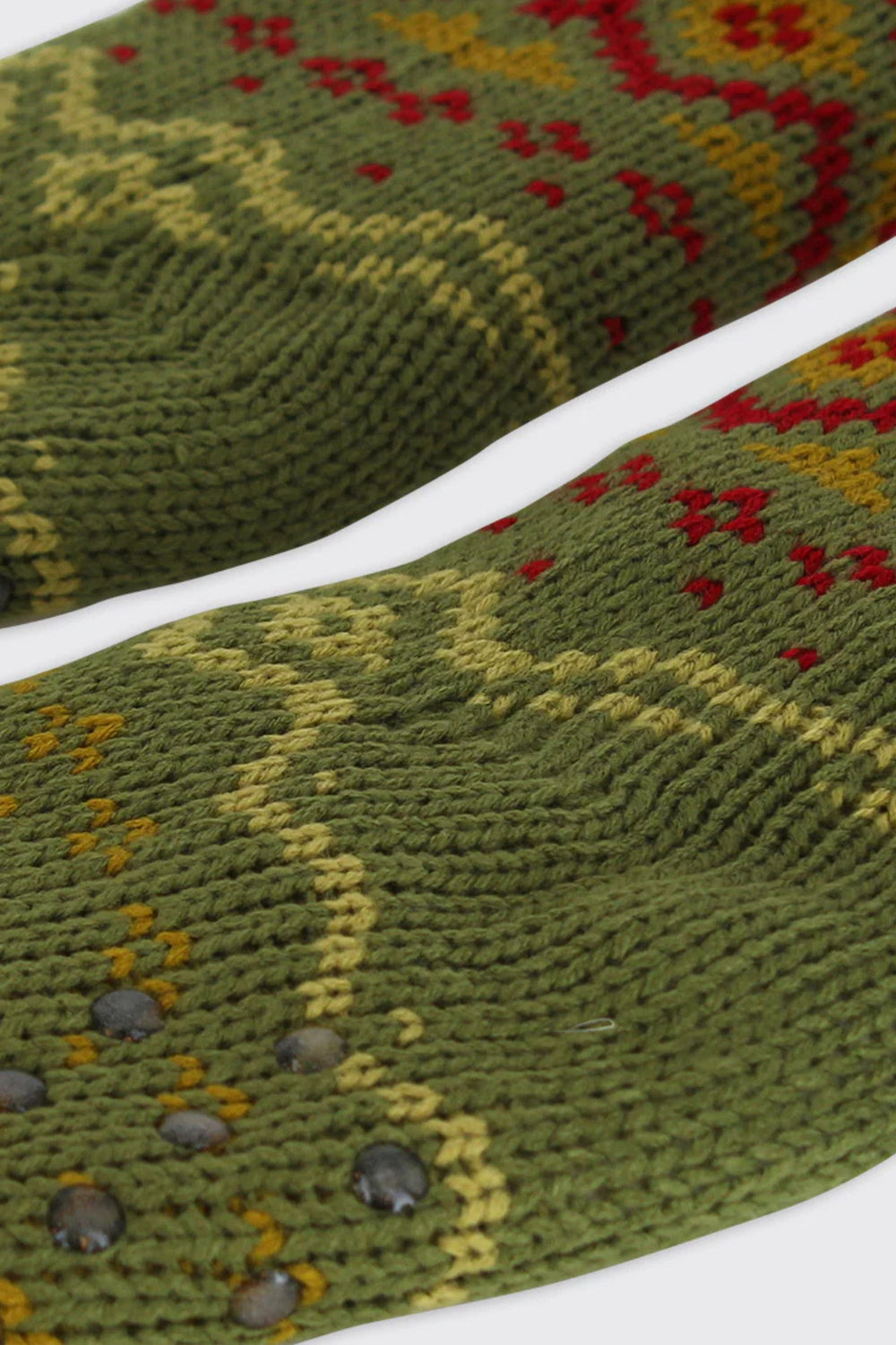 Close-up of green knitted fabric with a pattern on a white background