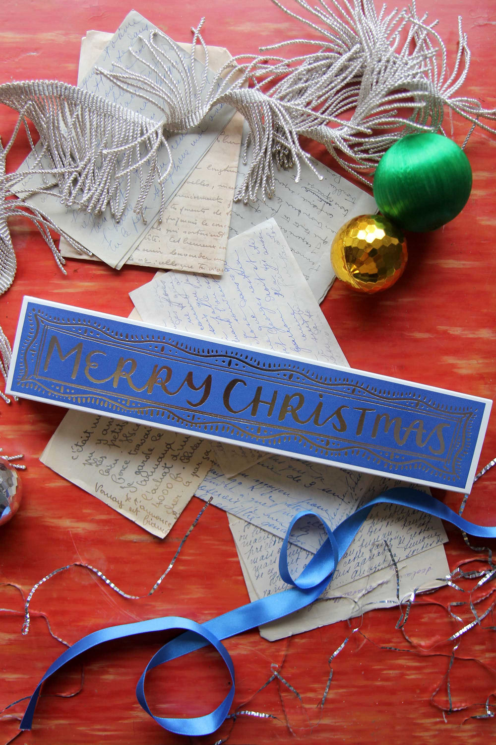 Decorative Christmas matches with 'Merry Christmas' on a red surface with festive elements.