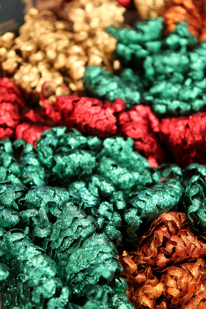 Close-up of colorful textured fabric in red, green, and gold.