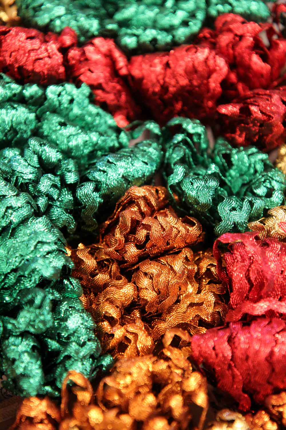 Close-up of colorful textured fabric with red, green, and gold patterns.