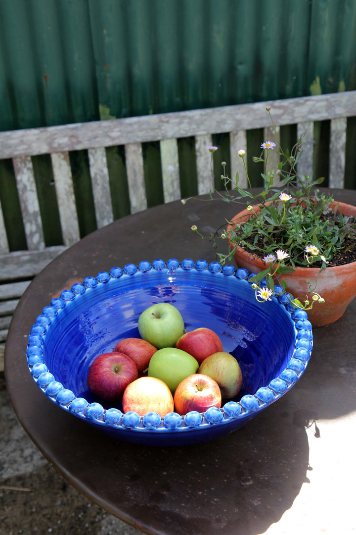 ceramic pearl serving dish in deep cobalt blue on garden table with apples