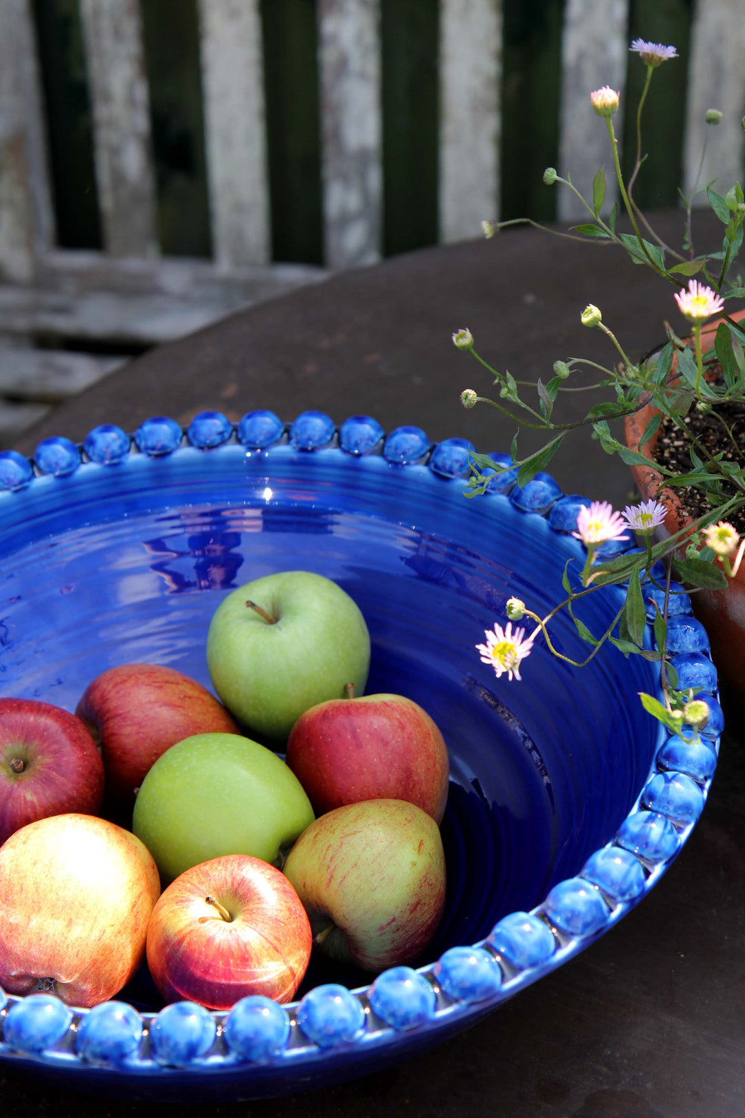 ceramic pearl serving dish in deep cobalt blue on garden table with apples