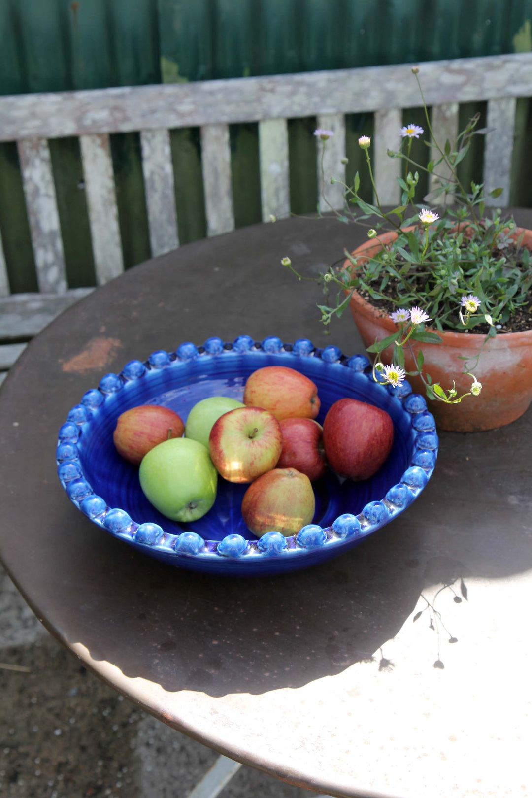 ceramic pearl serving dish in deep cobalt blue on garden table with apples