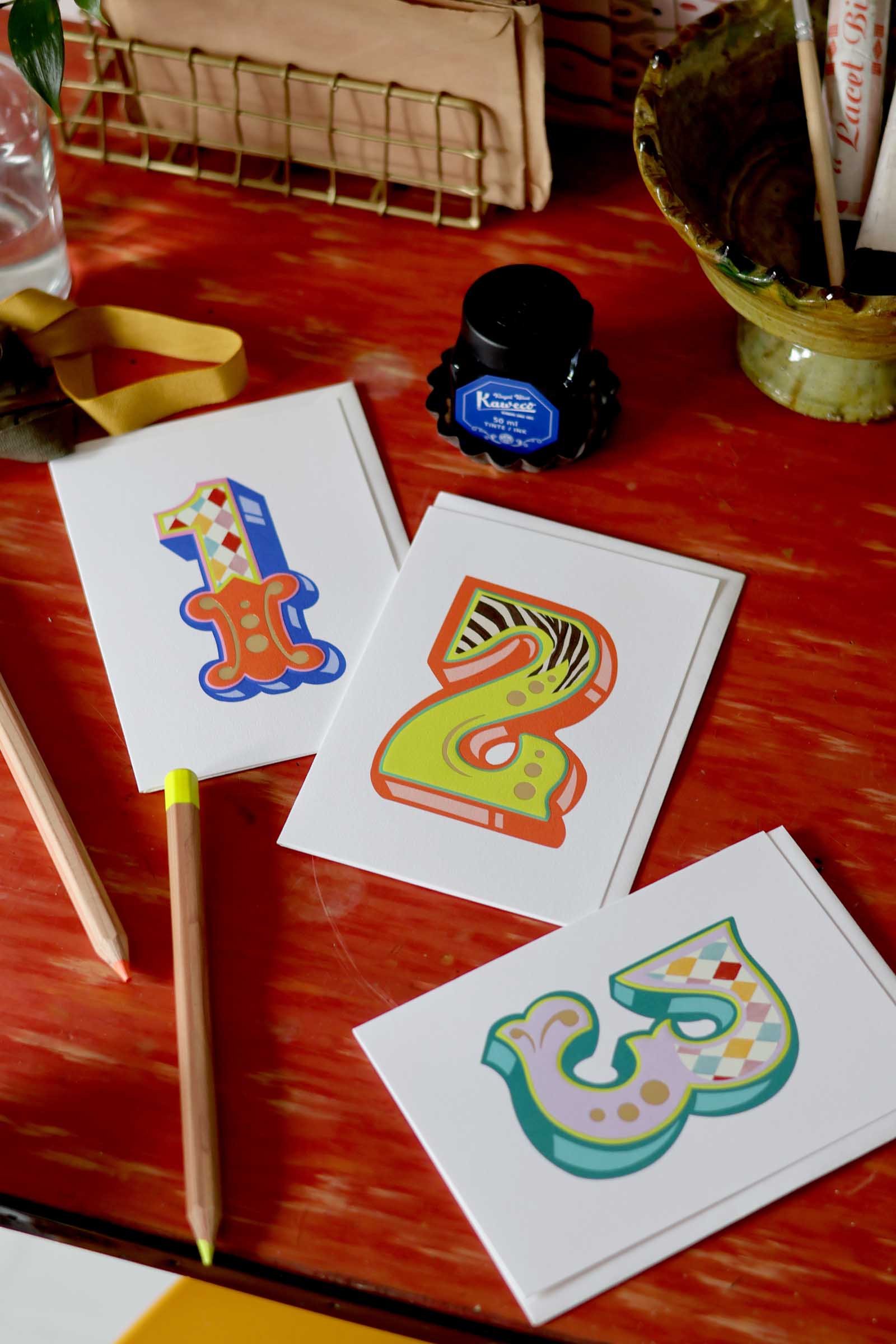 Colorful number cards on a wooden surface with writing utensils.