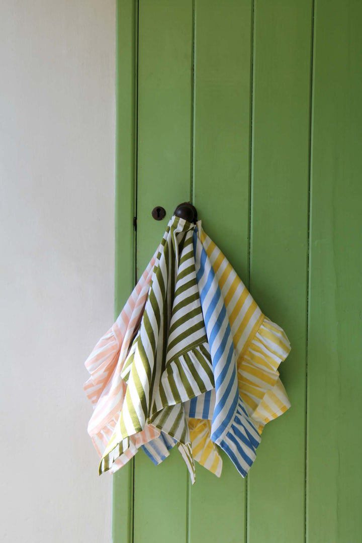 Colorful striped towels hanging on a green door