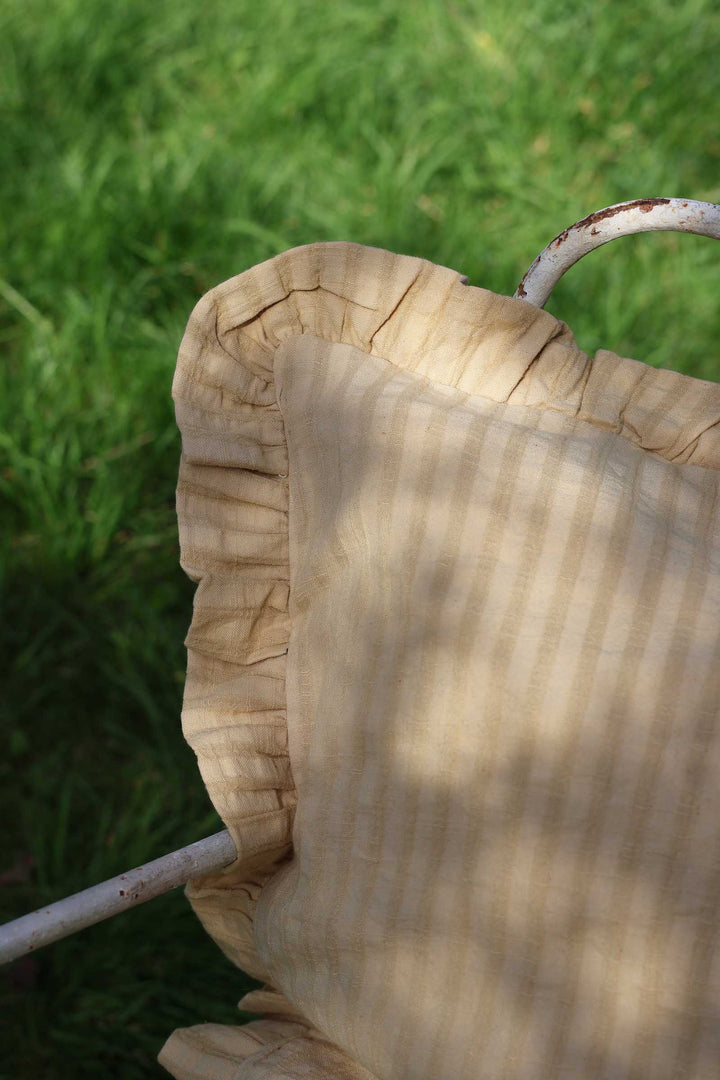 Close-up of a woven basket with a metal handle against a grassy background