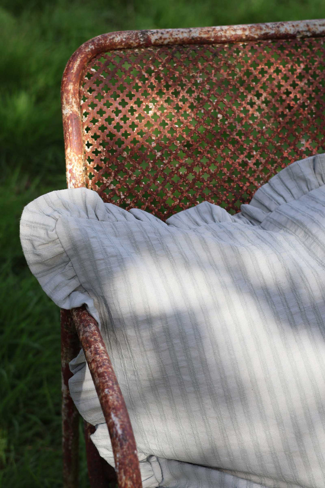 Rustic chair with a textured cushion on a grassy background
