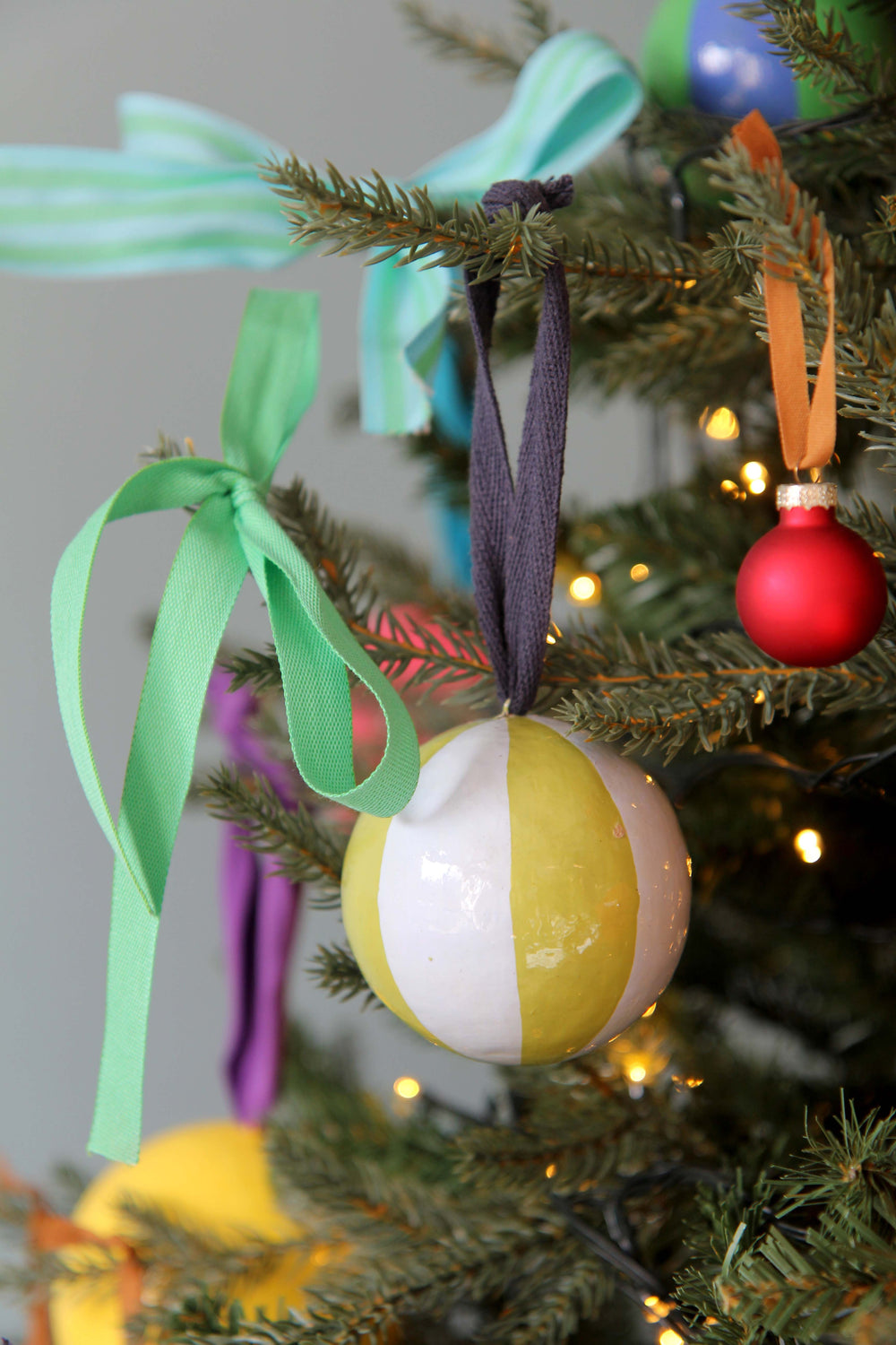 Colorful Christmas ornaments on a tree with ribbons