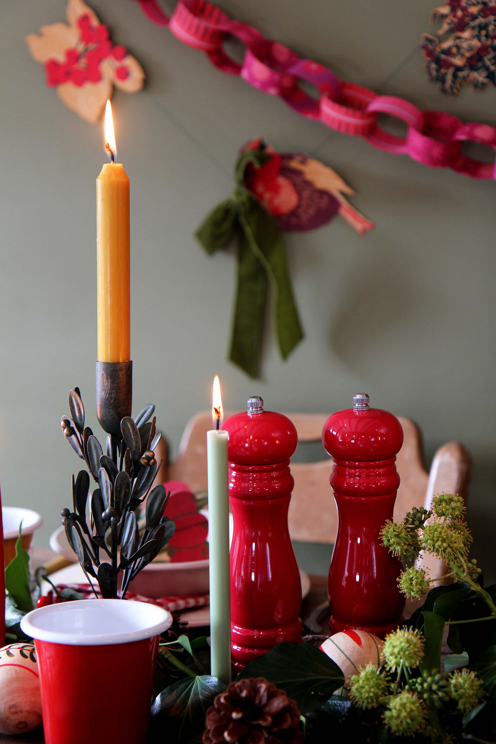 Decorative table setting with candles, red cups, and festive decorations.