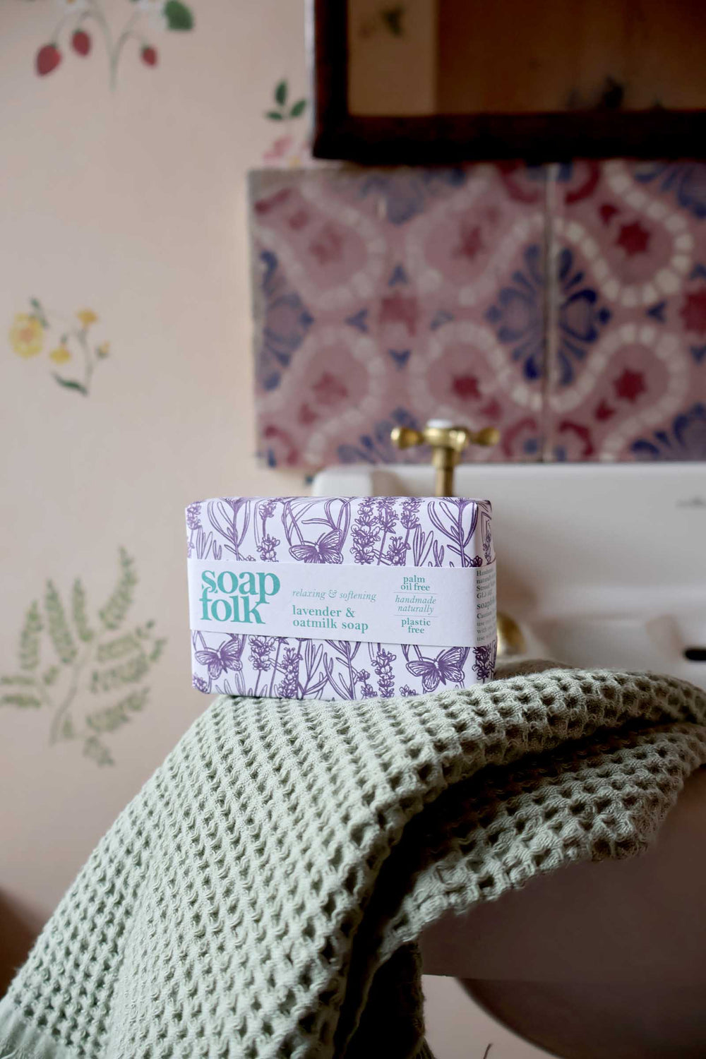 Bar of soap on a towel with a decorative bathroom background