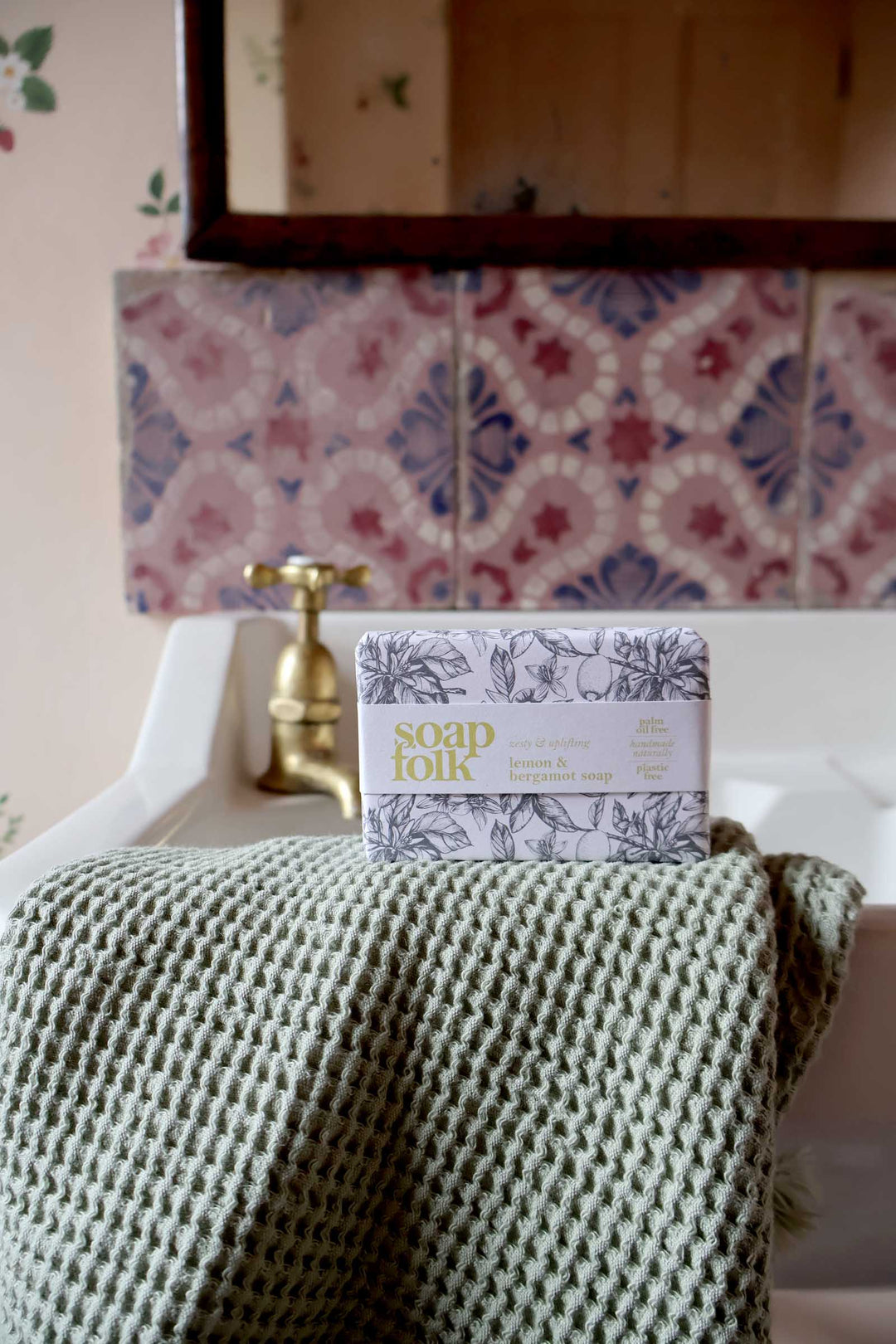 Box of Soap & Glory on a bed with a patterned headboard