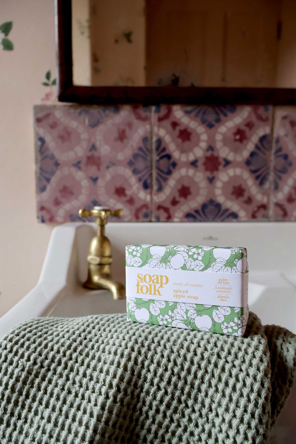 Soap Folk bar of soap on a towel with a patterned tile backsplash