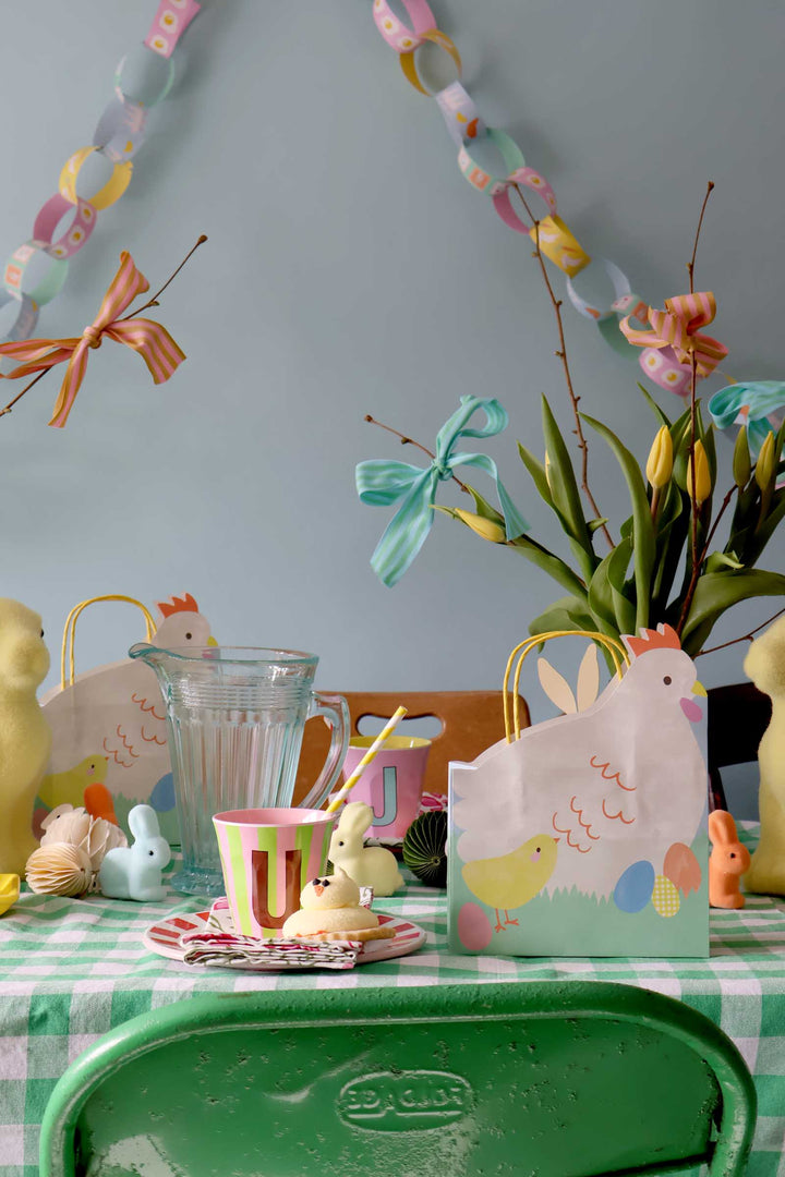Easter-themed table setting with decorative items and a green chair.
