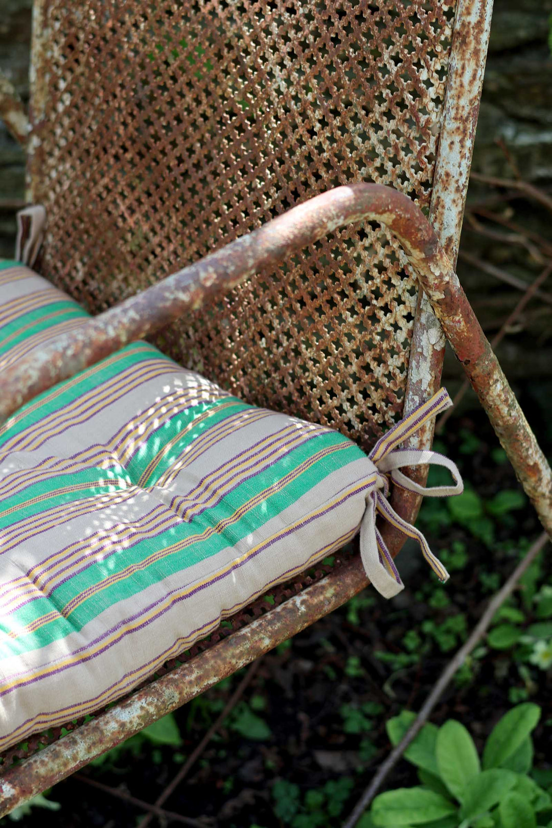 Rustic chair with a green cushion in an outdoor setting