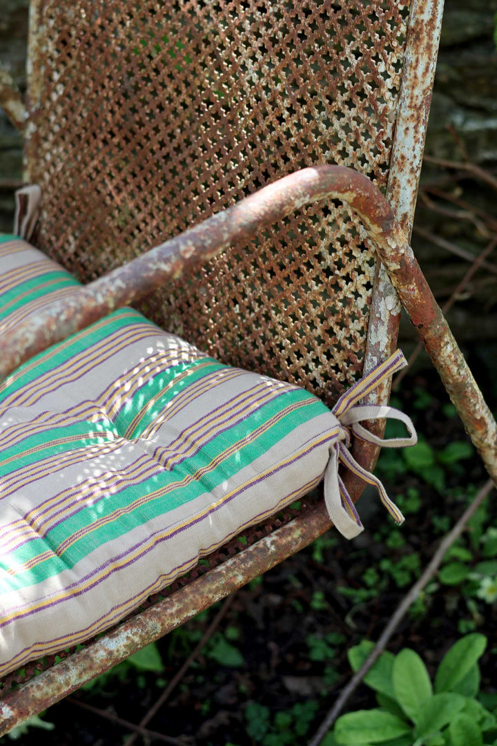 Rustic chair with a green cushion in an outdoor setting
