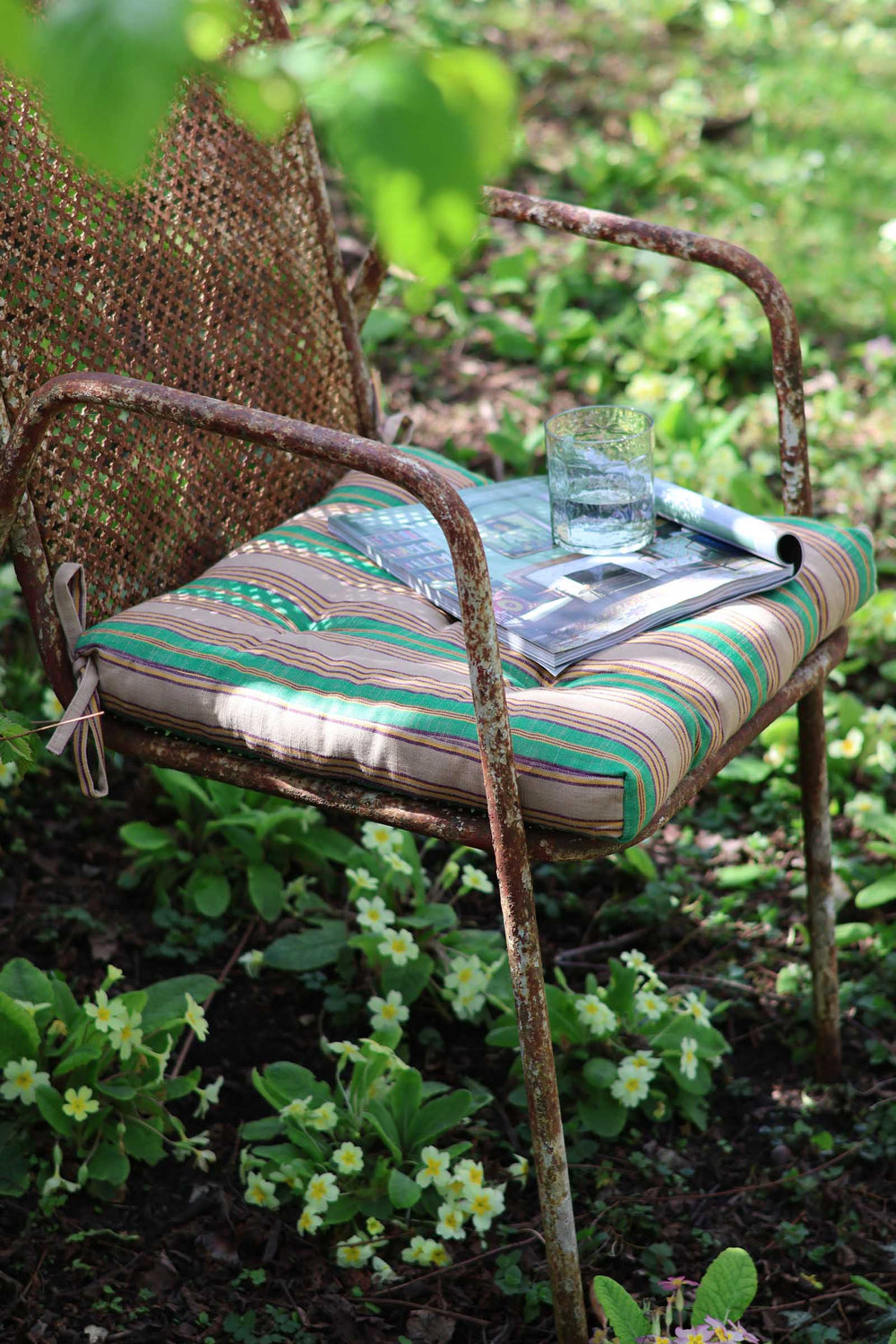 Rustic metal chair with a striped cushion in a garden setting