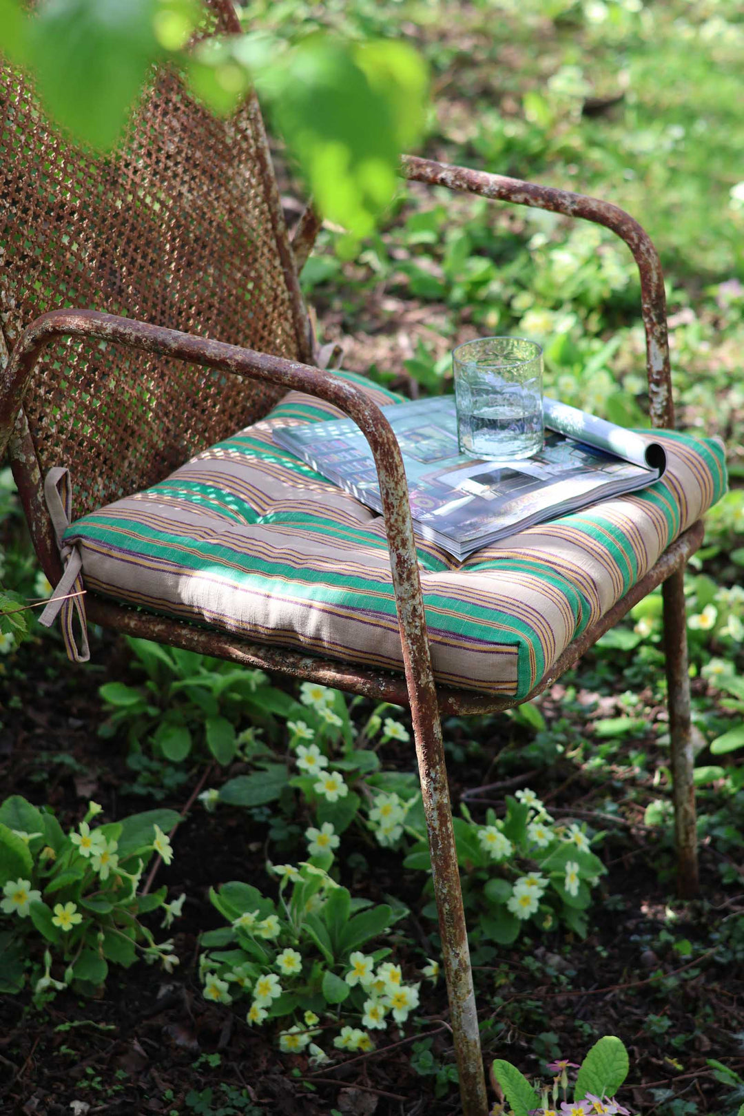 Rustic metal chair with a striped cushion in a garden setting