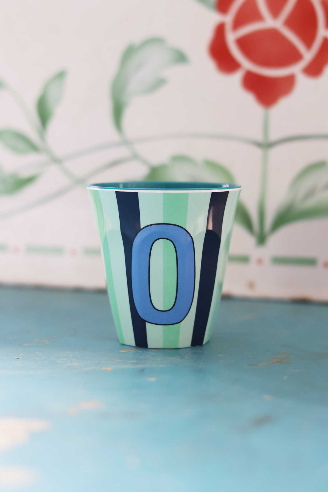 Colorful cup with number '0' on a blue surface
