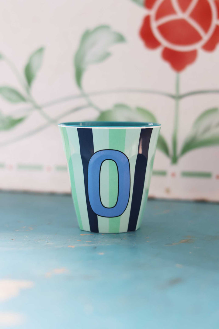 Colorful cup with number '0' on a blue surface
