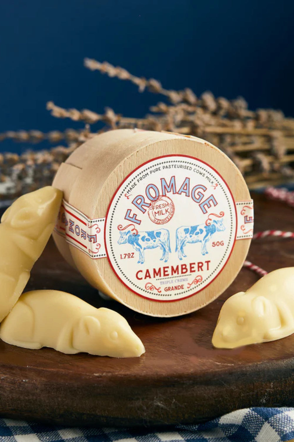 Round of Camembert chocolate with a decorative label on a wooden board.