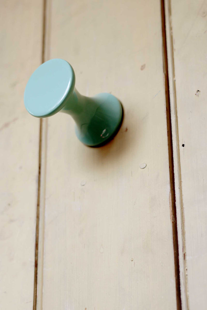 Green cabinet knob on a wooden door