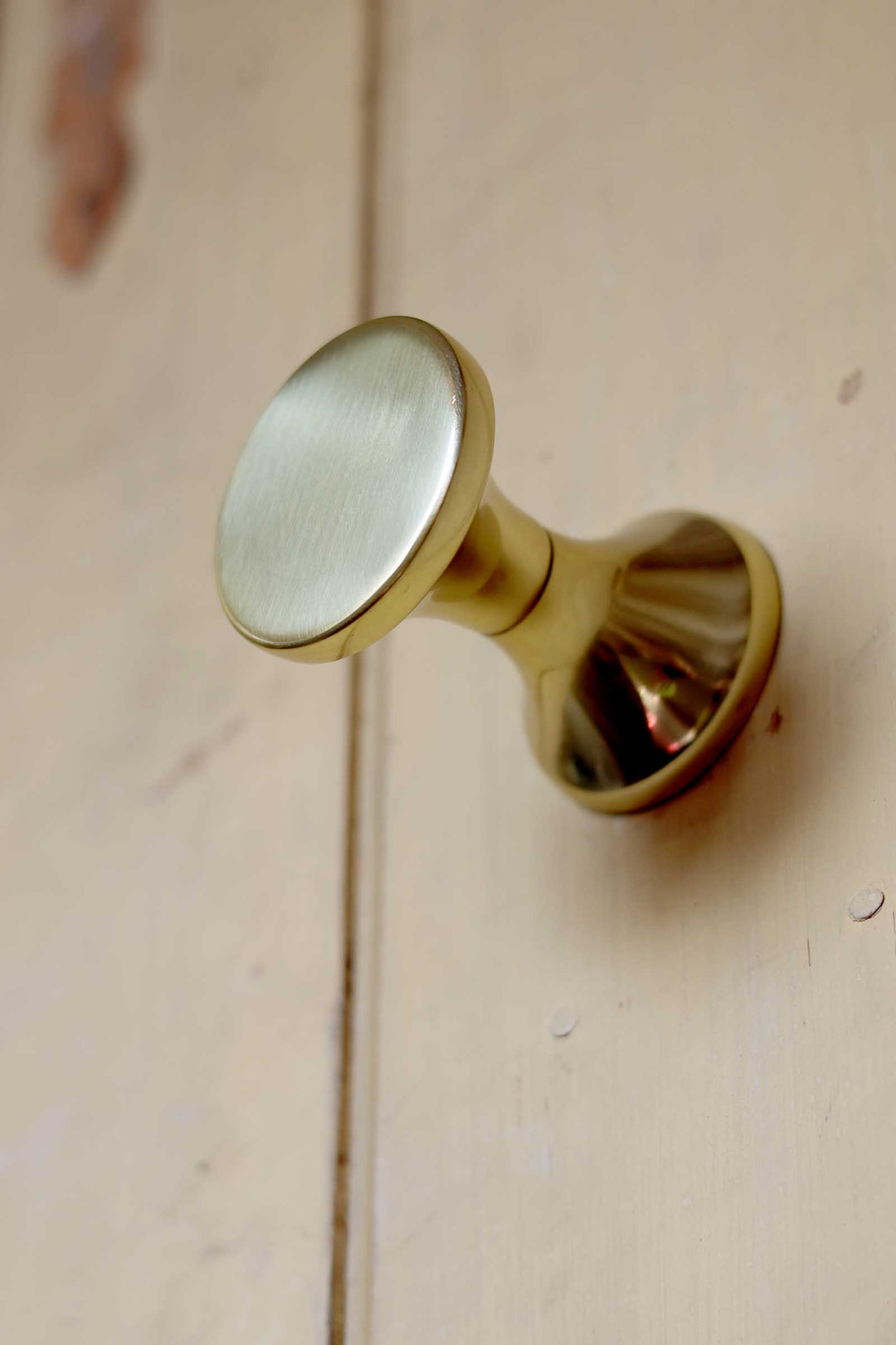 Gold cabinet knob on a wooden surface