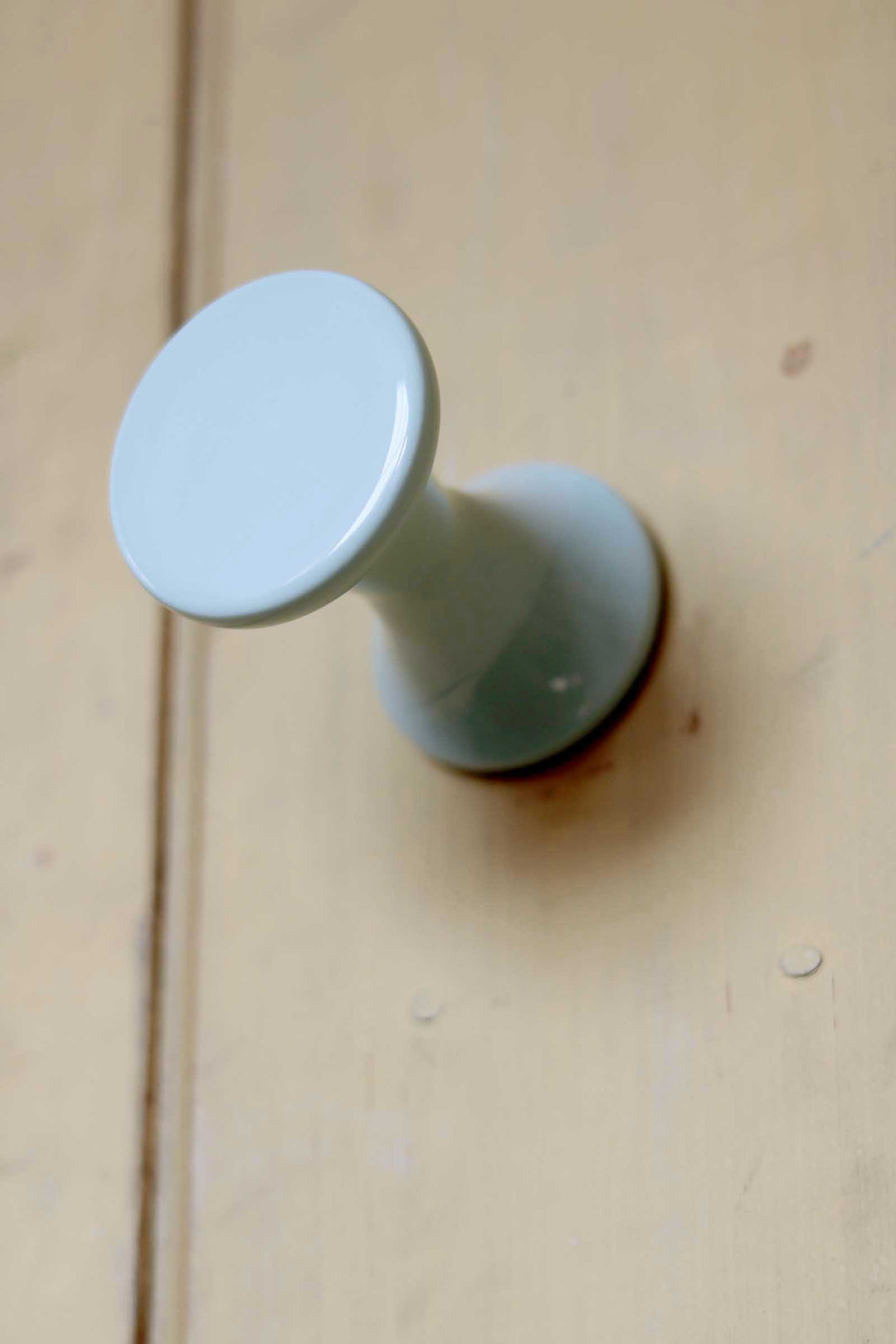 Light blue cylindrical object on a beige surface