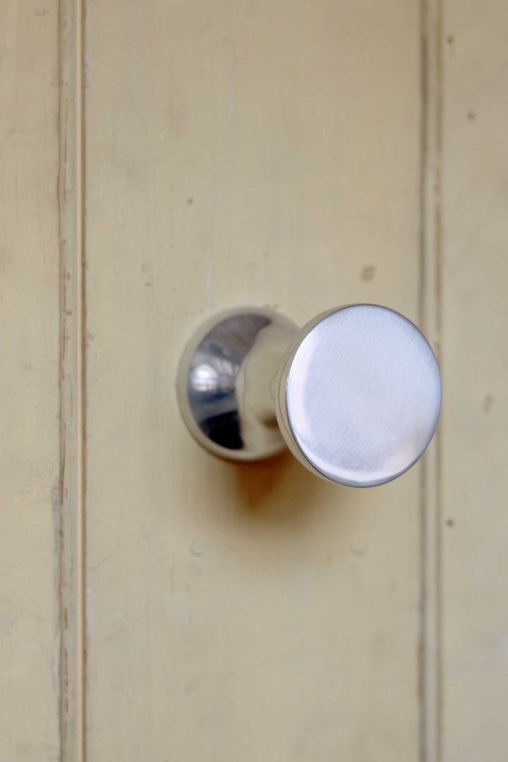 Round metallic doorknob on a wooden door