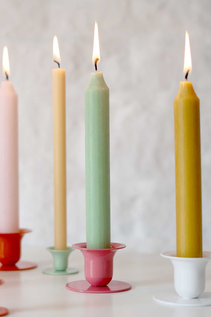 Colorful candles in holders on a white background