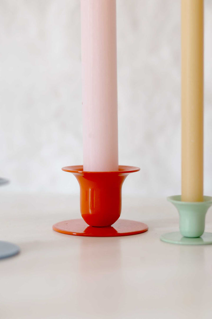 Two candle holders with candles on a white background