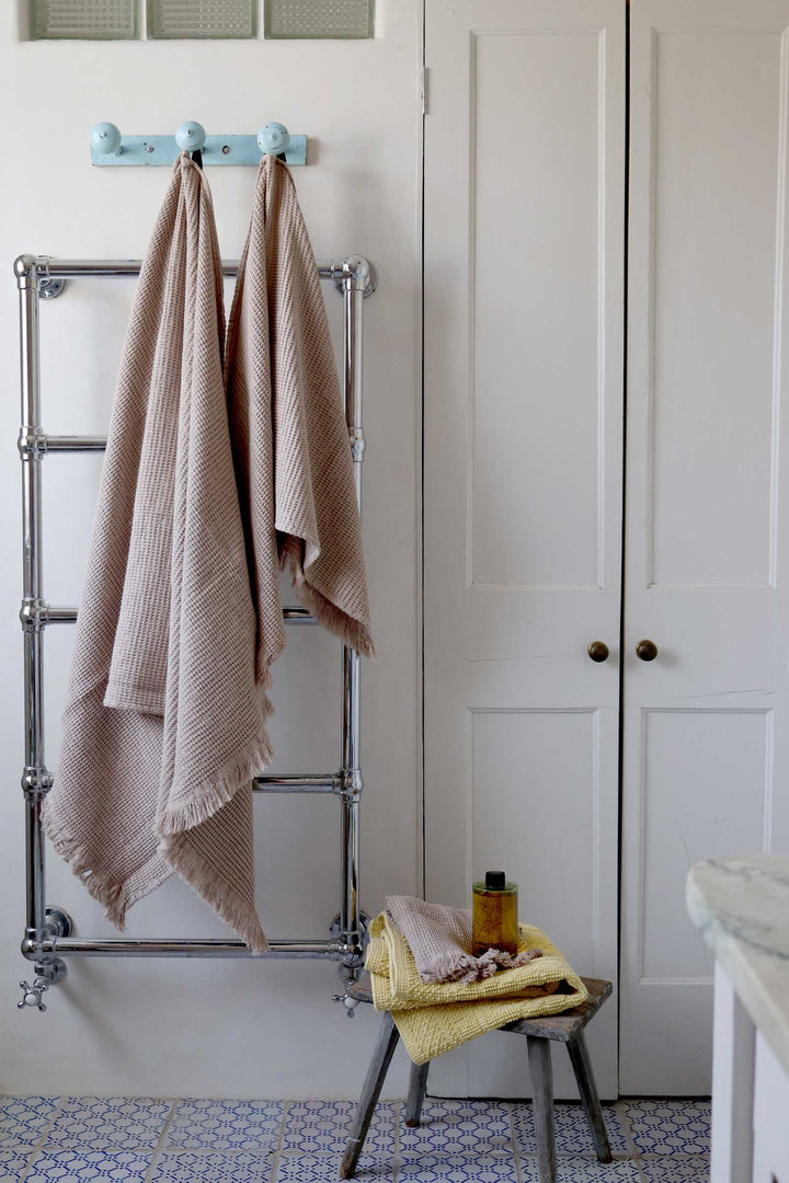 Towels hanging on a towel rack in a bathroom setting.