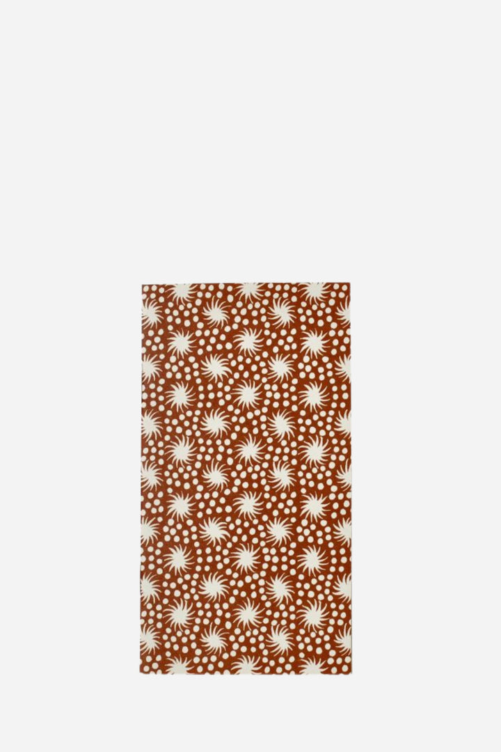 Patterned fabric with white starburst design on a brown background