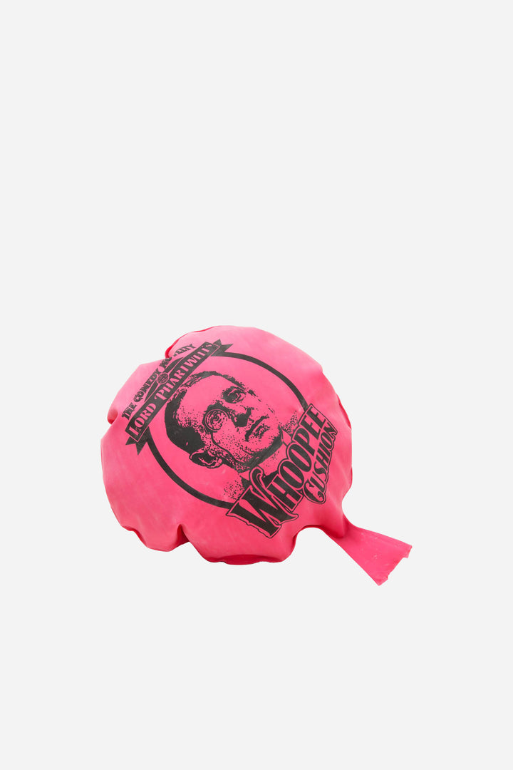 Pink whoopee cushion balloon with a printed design on a white background