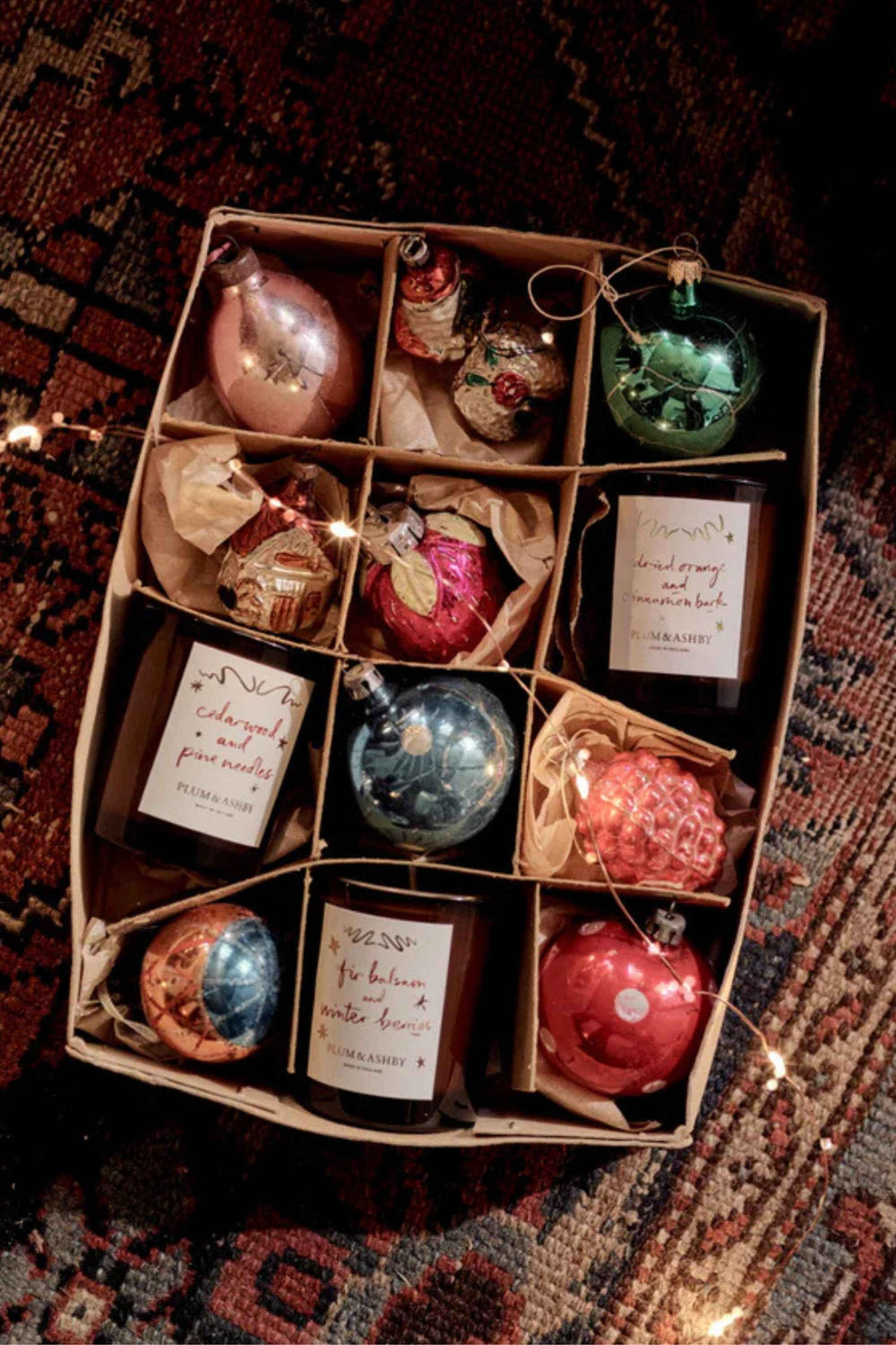Box of Christmas ornaments with labels on a patterned rug