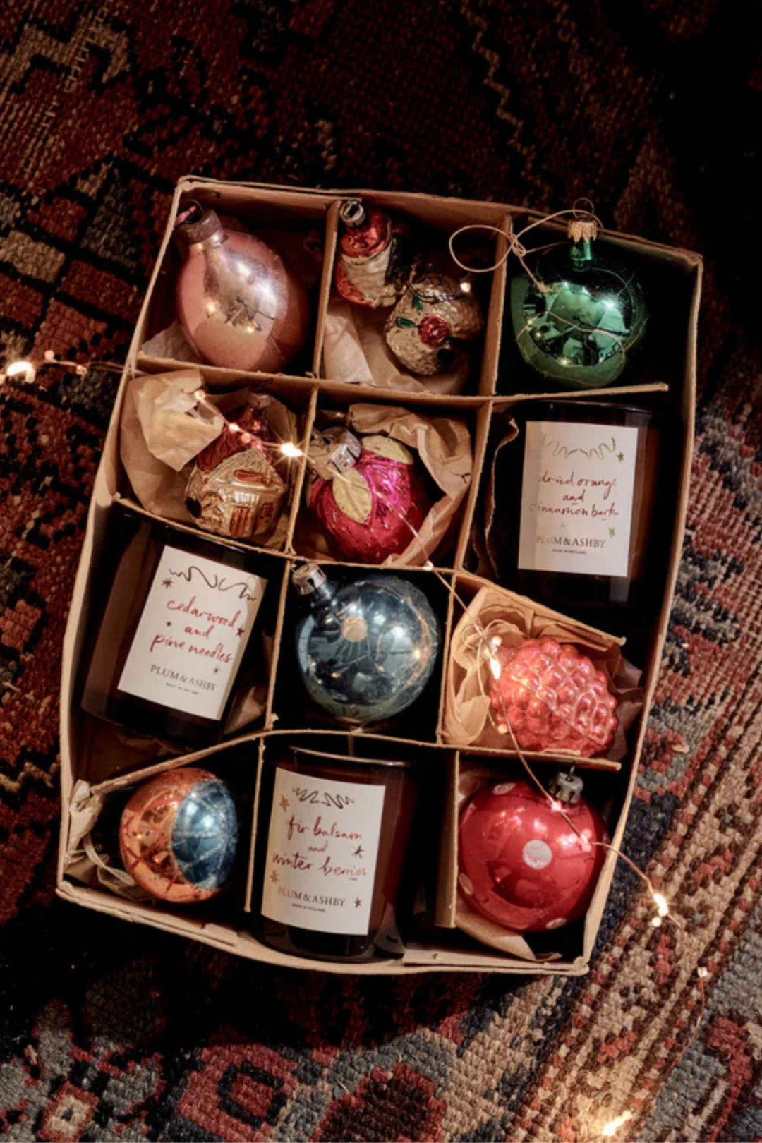 Box of Christmas ornaments with labels on a patterned rug
