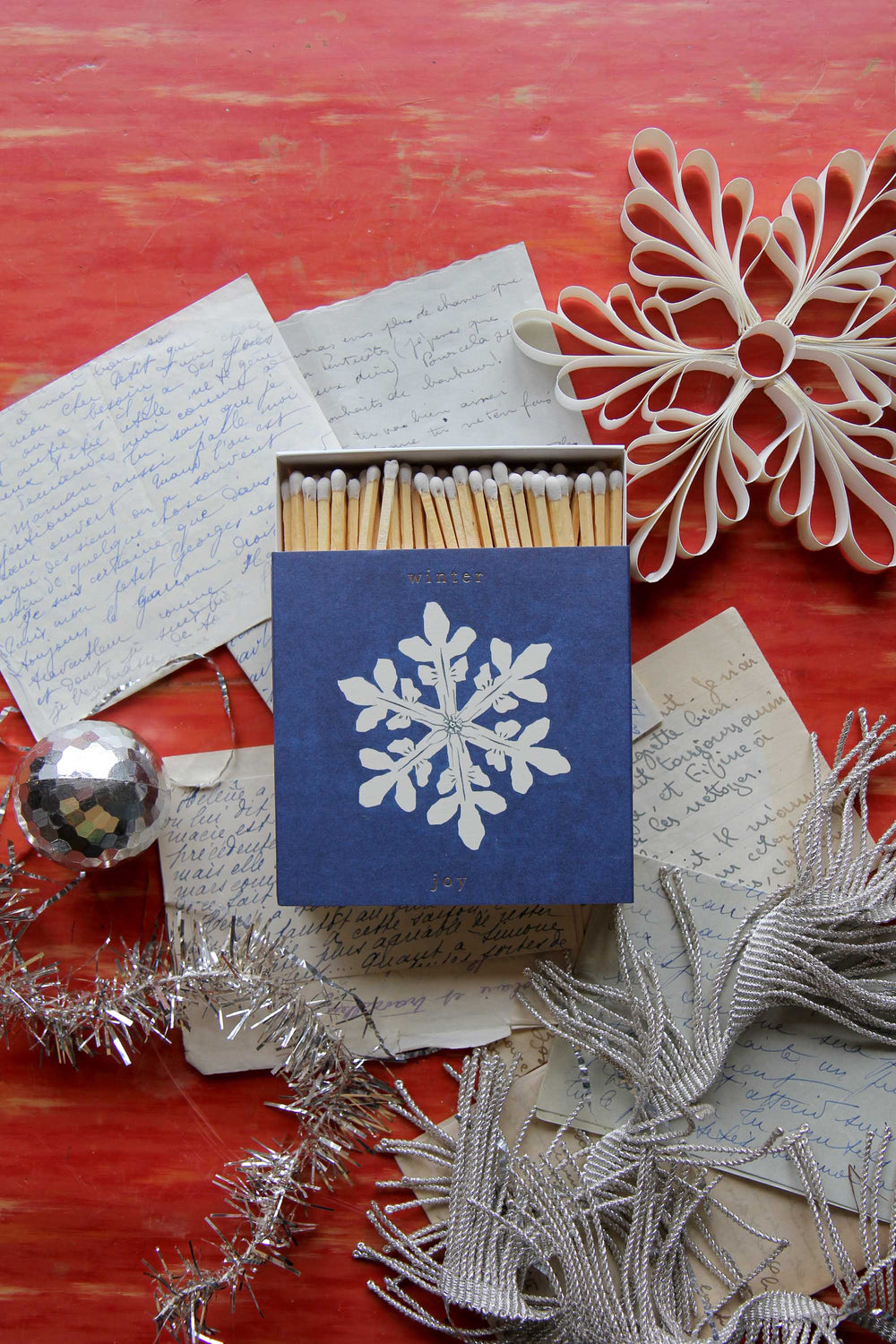 Matches with a snowflake design on a red surface with decorative elements