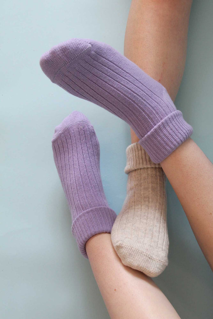 Purple and beige socks on a light blue background