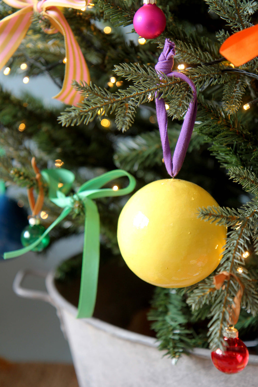Decorative Christmas tree with colorful yellow ornament and ribbons