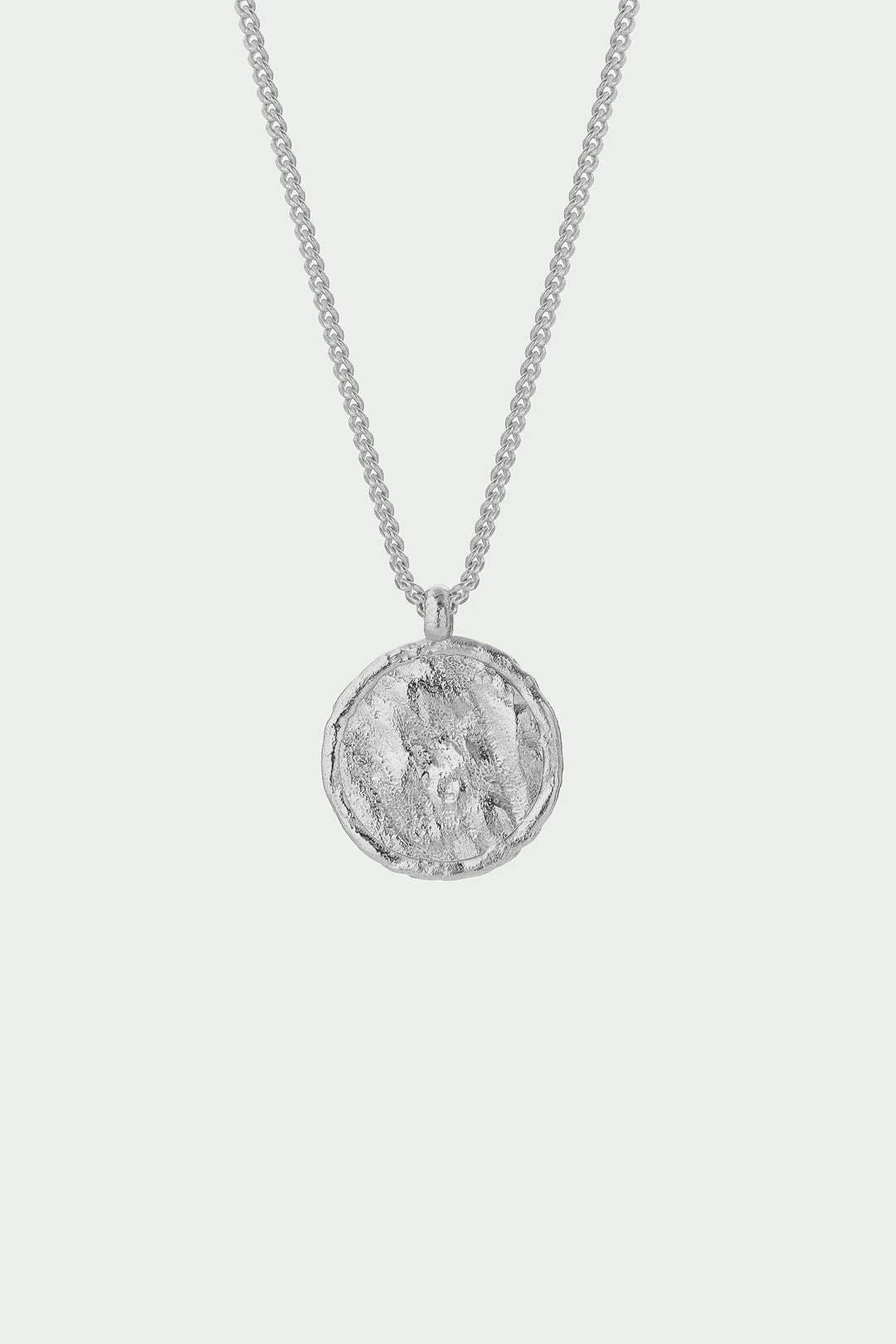 Silver necklace with a round pendant on a light gray background