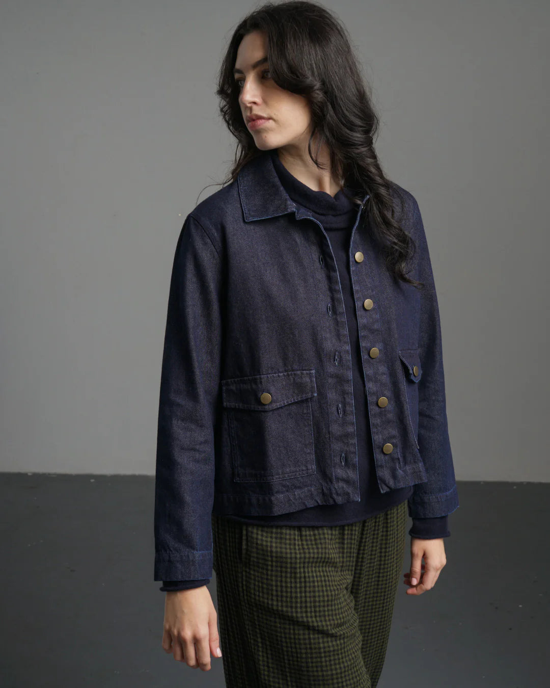 Woman wearing a dark blue jacket with a gray background