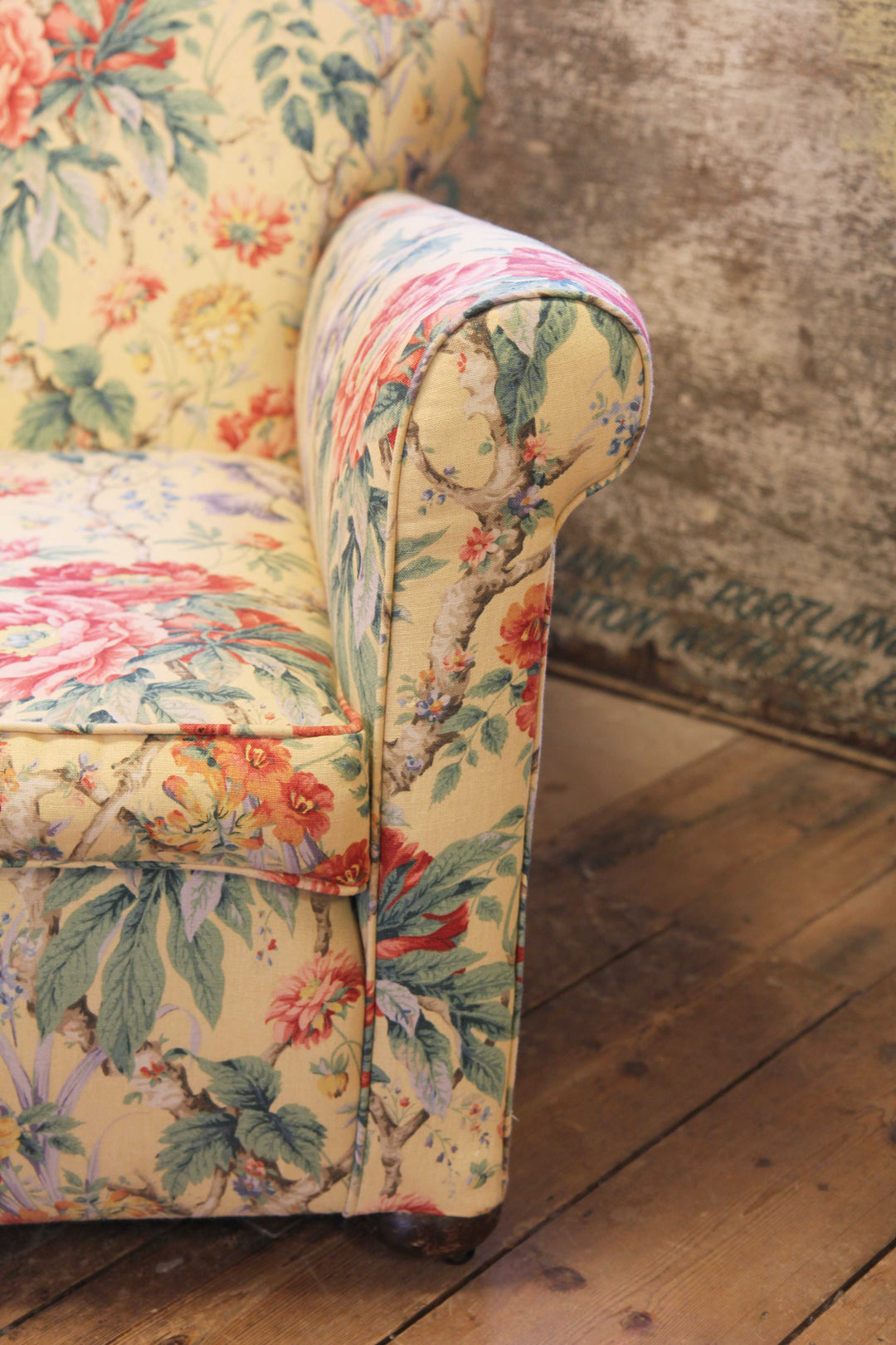 arm rest of yellow, red and green floral upholstered vintage armchair 