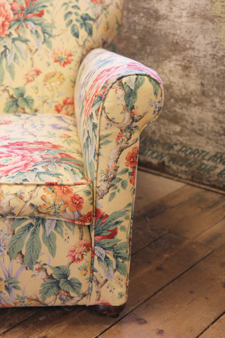 arm rest of yellow, red and green floral upholstered vintage armchair 