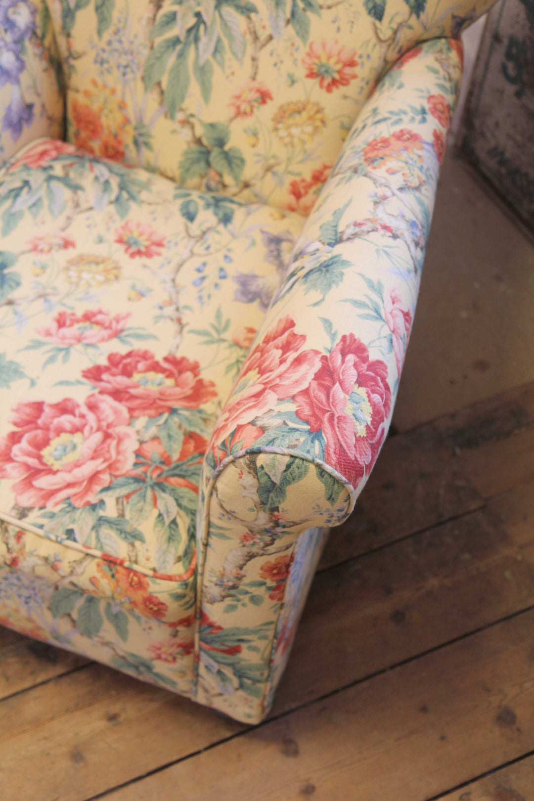 fabric detail of yellow, red and green floral upholstered vintage armchair