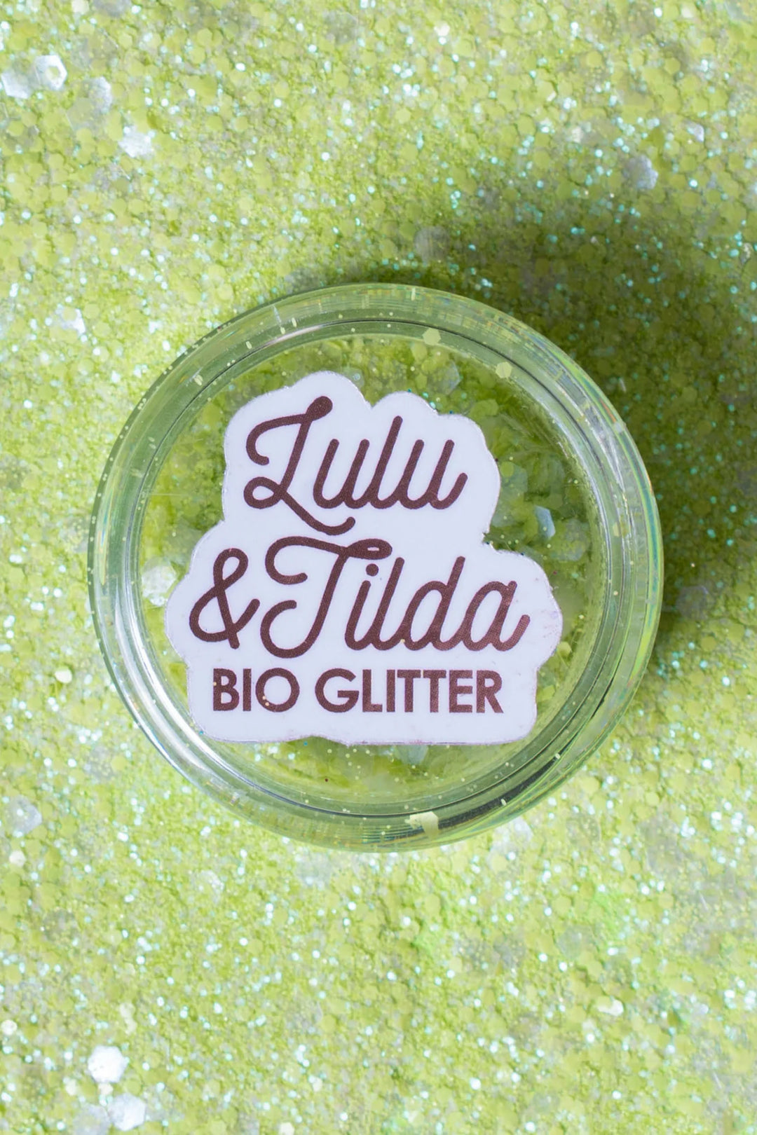 Jar of green glitter with 'Lulu & Tilda Bio Glitter' label on a glittery background